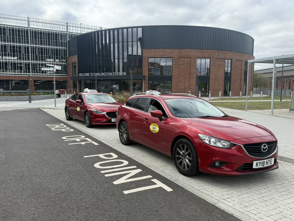 Two C&P Taxis vehicles waiting outside Darlington Station